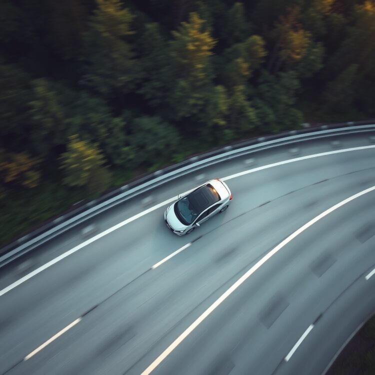 An aerial shot of a hybrid car driving on a highway, with a focus on the vehicle's efficiency and the surrounding environment, highlighting fuel economy.