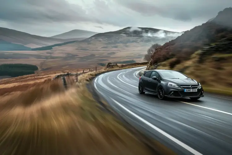 A Corsa VXR driving fast on a scenic road, showcasing its sporty design and dynamic performance.